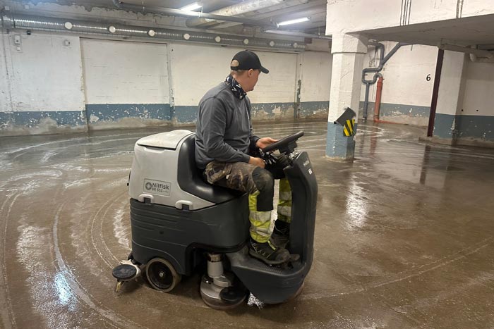Medarbetare som sitter på en maskin och behandlar golvet mot damm